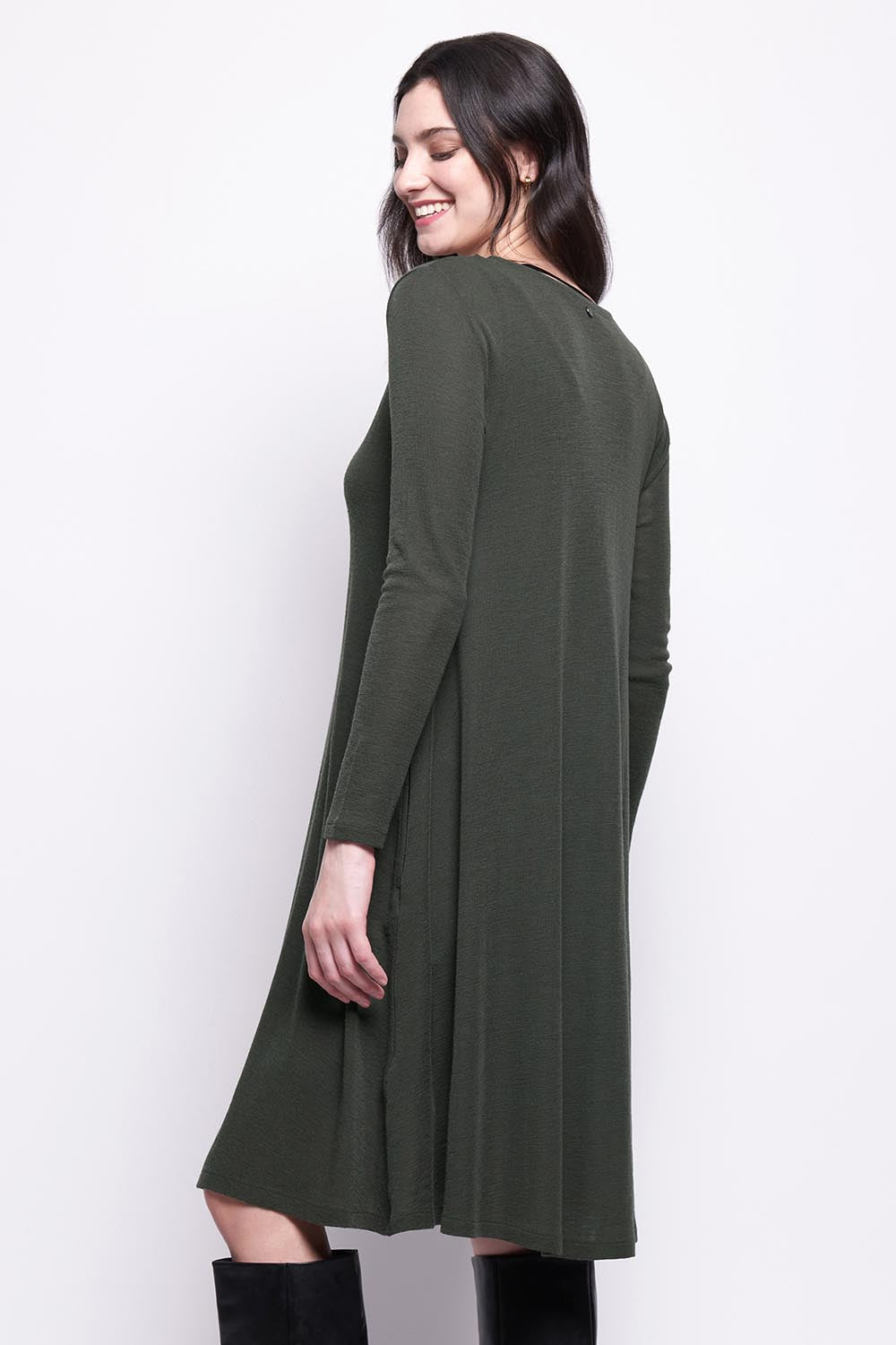 A model wearing the Merino Shear Delight Dress in colour Moss (Green), from the back