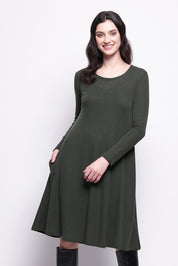 A model wearing the Merino Shear Delight Dress in colour Moss (Green), from the front, cropped image