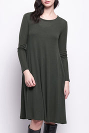 A model wearing the Merino Shear Delight Dress in colour Moss (Green), from the front, cropped image