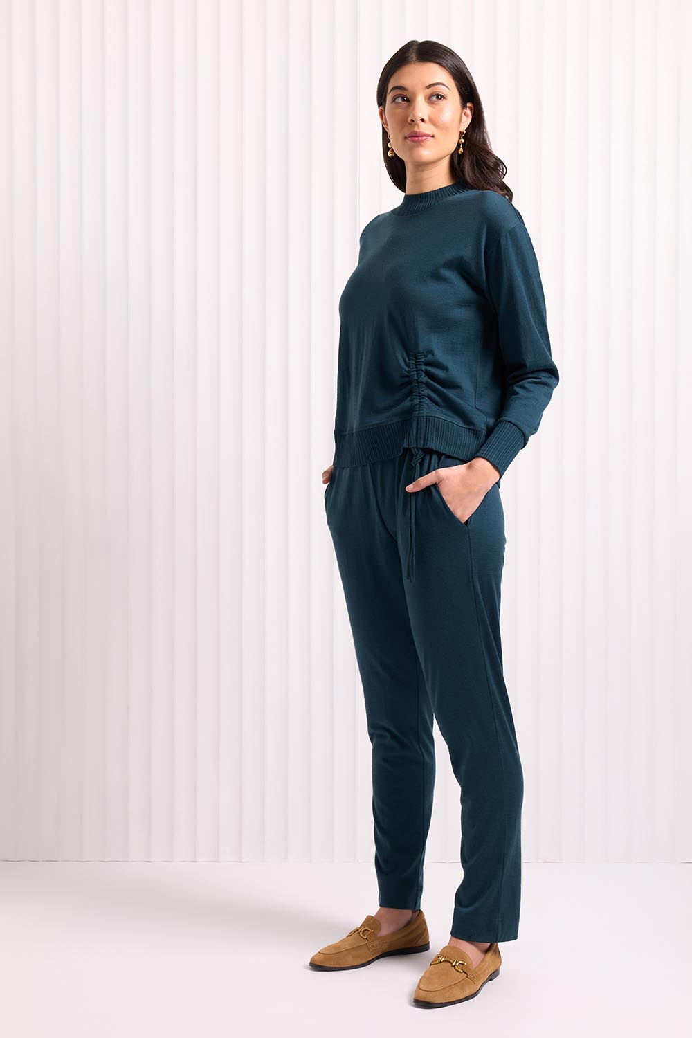 A model wearing the Merino Best Side Top in colour Jeep (Green), from the front, showing the whole outfit