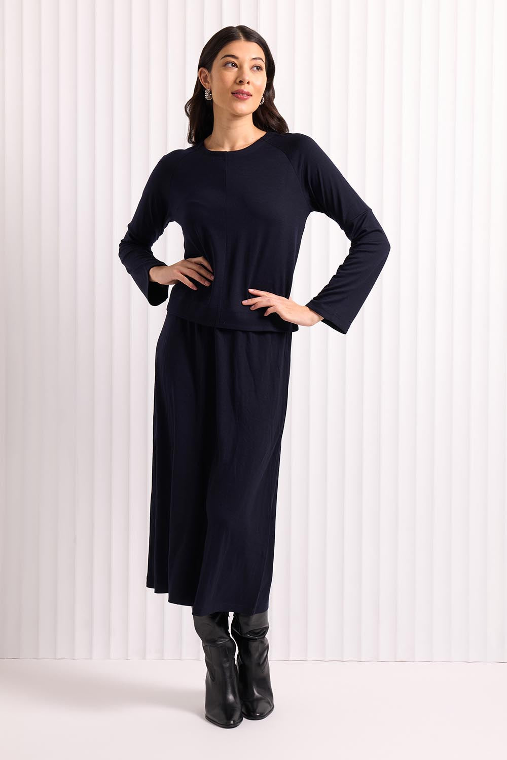 A model wearing the Merino Belong Together Sweater in colour Futuredusk (Blue), from the front, showing the whole outfit