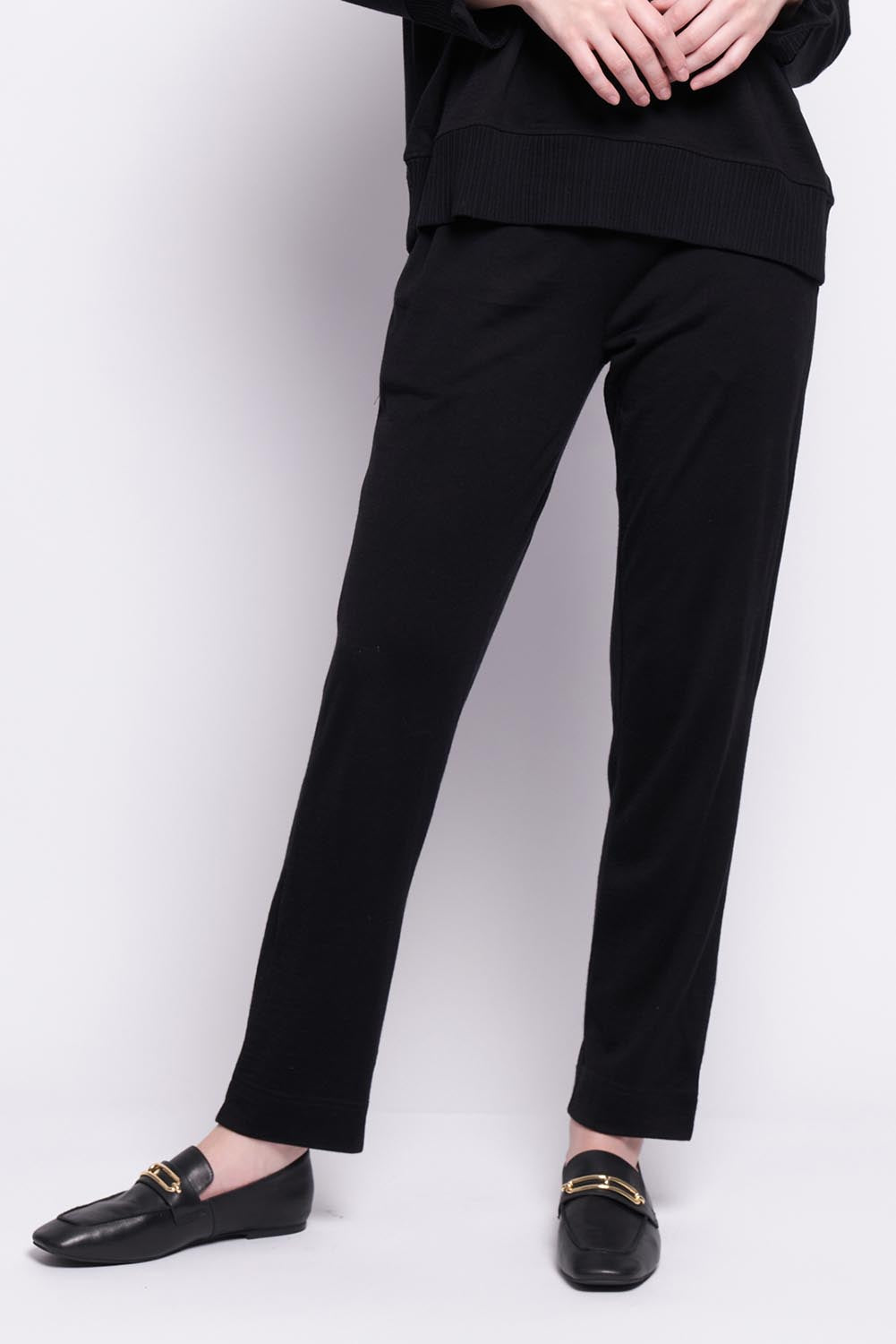 A model wearing the Merino Lazy Sunday Jogger in colour Black (Black), from the front, cropped image