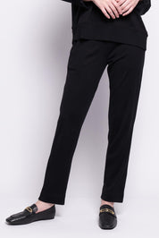 A model wearing the Merino Lazy Sunday Jogger in colour Black (Black), from the front, cropped image
