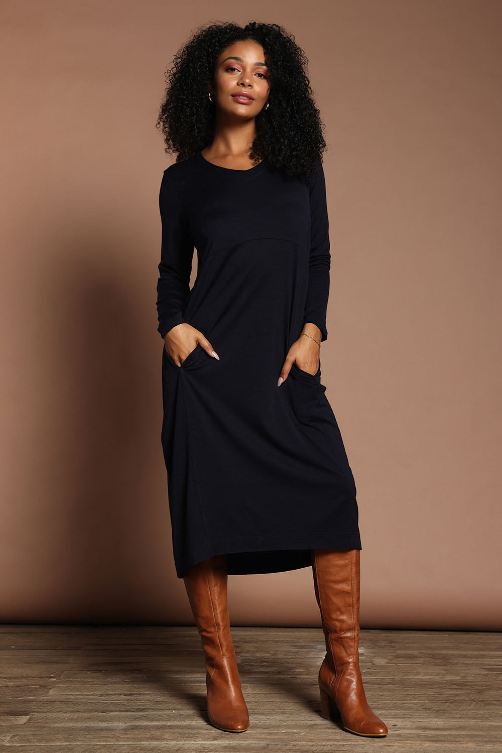 Model Ziara wearing size S of the Merino Line Dancing Dress in colour Futuredusk (Blue), from the front, showing the whole outfit