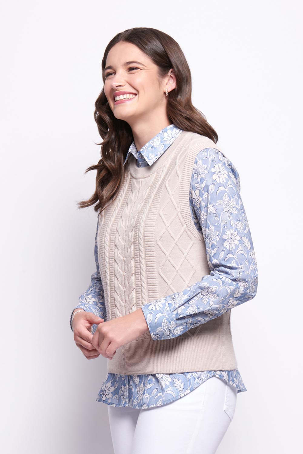 A model wearing the Merino Plot Twist Vest in colour Pearl, from the front, cropped image