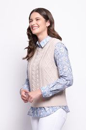 A model wearing the Merino Plot Twist Vest in colour Pearl, from the front, cropped image