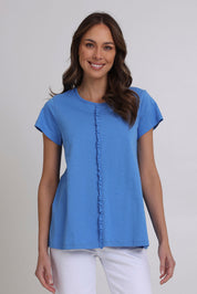 Model Madeline wearing size S of the Frill Factor Cotton Tee in colour Regatta (Blue), from the front, cropped image