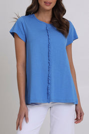 Model Madeline wearing size S of the Frill Factor Cotton Tee in colour Regatta (Blue), from the front, cropped image