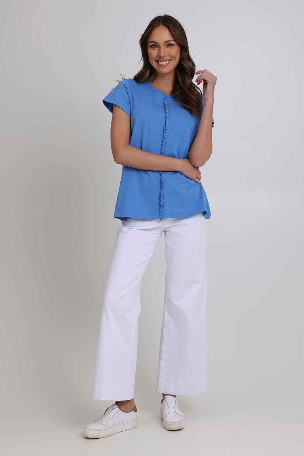 Model Madeline wearing size S of the Frill Factor Cotton Tee in colour Regatta (Blue), from the front, showing the whole outfit
