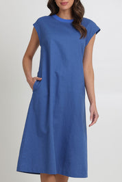 Model Madeline wearing size 10 of the Cut Of Your Rib Dress in colour Savoyblue (Blue), from the front, cropped image