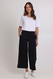 Model Madeline wearing size 10 of the Broad Horizons Cotton Blend Pant in colour Black (Black), from the front, showing the whole outfit