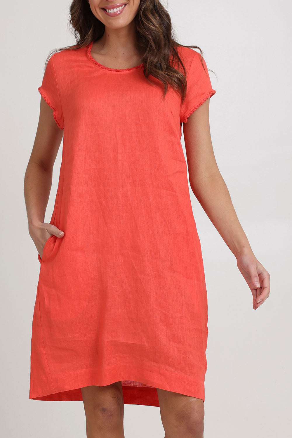 Model Madeline wearing size 10 of the Festival Linen Dress in colour Melon (Pink), from the front, cropped image