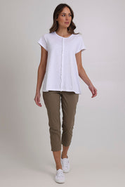 Model Madeline wearing size 10 of the Fuss Free 7/8 Pant in colour Dune (Green), from the front, showing the whole outfit
