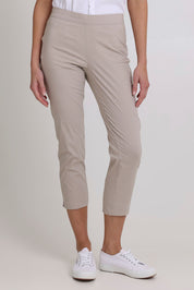 Model Madeline wearing size 10 of the Fuss Free 7/8 Pant in colour Sand, from the front, cropped image