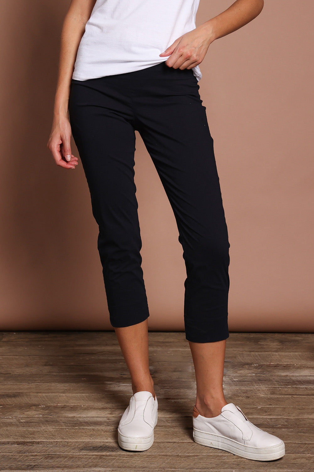 Model Madeline wearing size 10 of the Fuss Free 7/8 Pant in colour TrueNavy (Blue), from the front, cropped image
