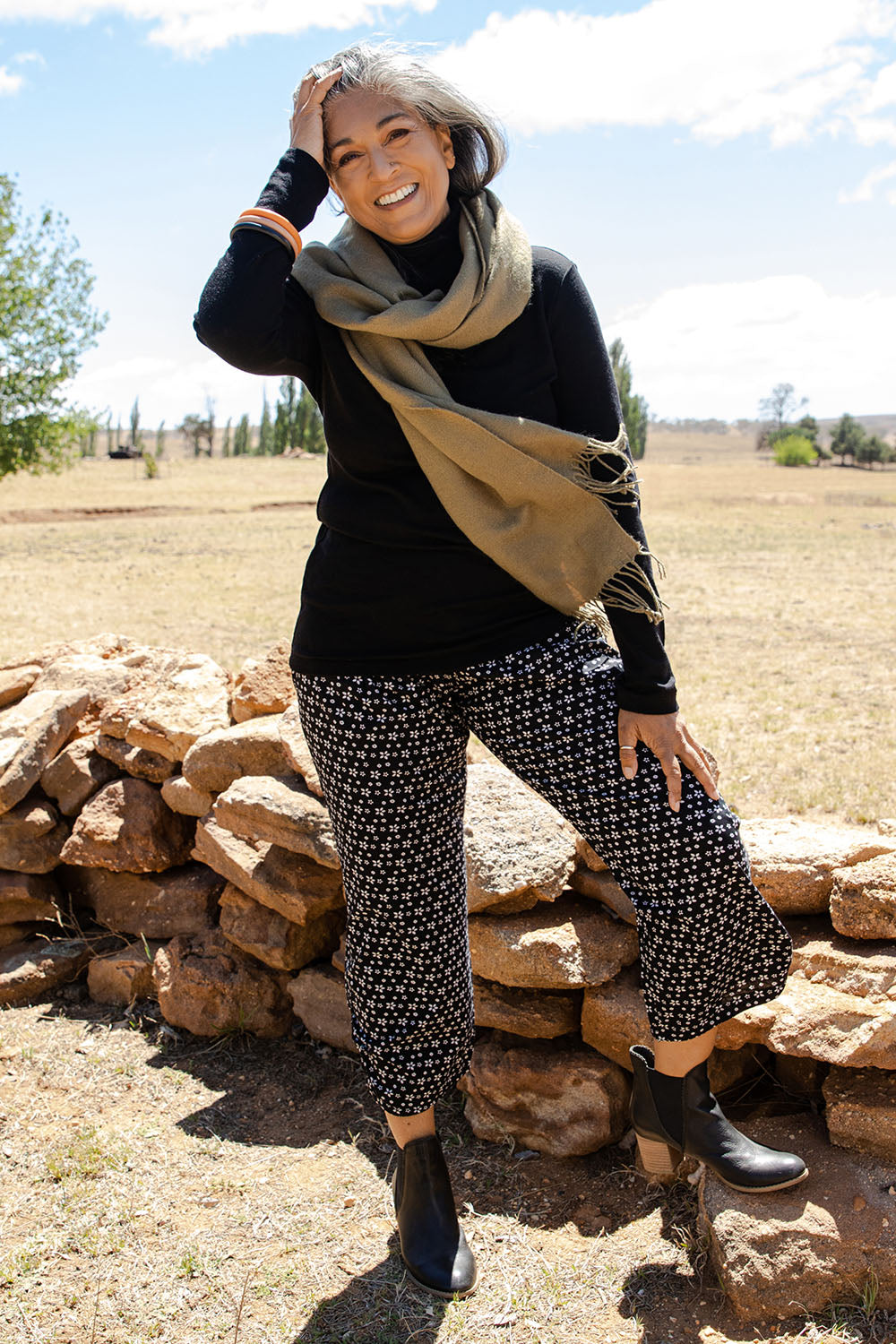Model Nadine wearing size S of the Pure Merino Rib Polo in colour Black (Black), from the front, showing the whole outfit