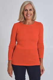 Model Sandy wearing size S of the Merino Signature Crew Top in colour Flash (Red), from the front, cropped image