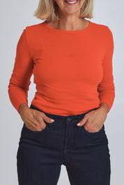 Model Sandy wearing size S of the Merino Signature Crew Top in colour Flash (Red), from the front, cropped image