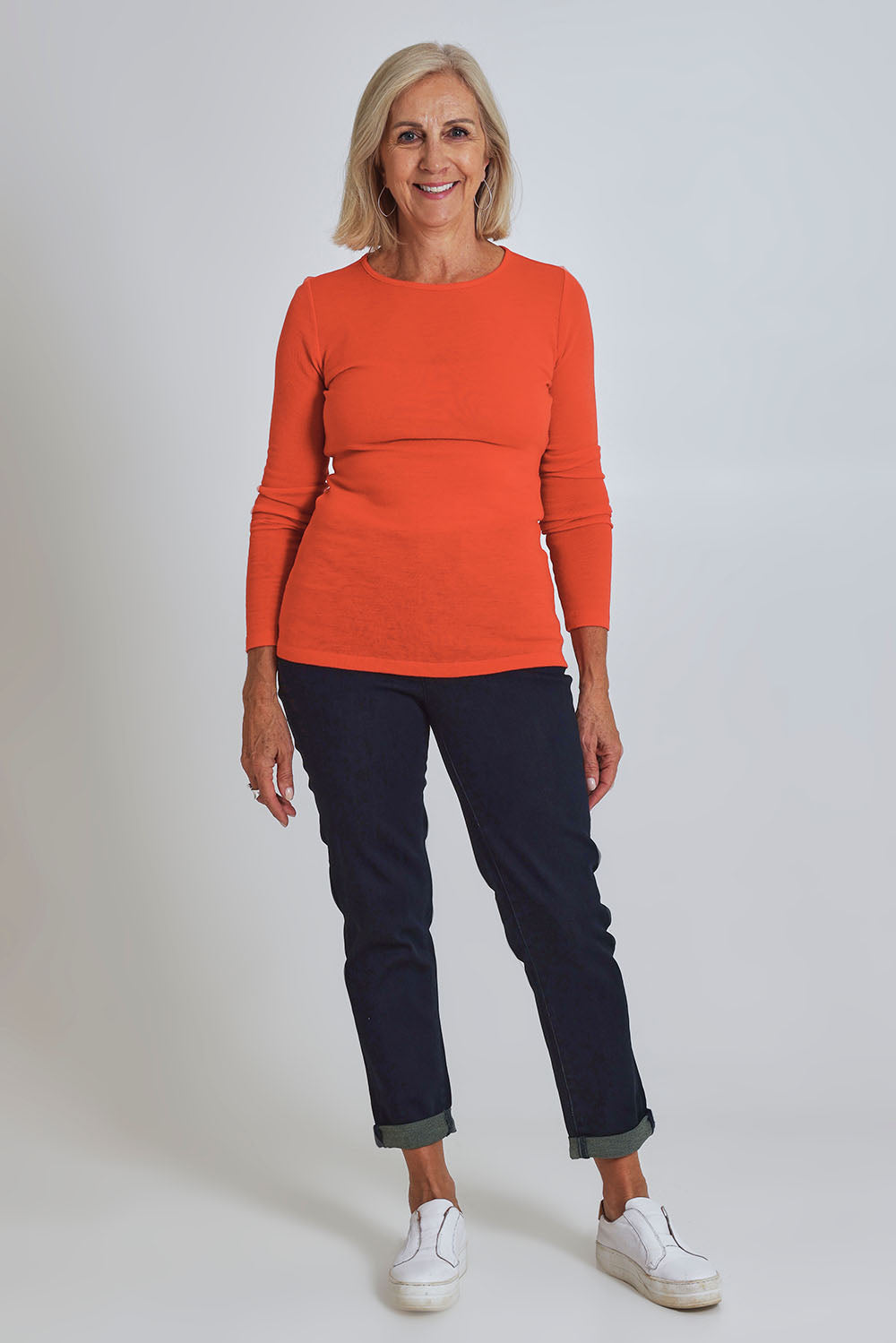 Model Sandy wearing size S of the Merino Signature Crew Top in colour Flash (Red), from the front, showing the whole outfit