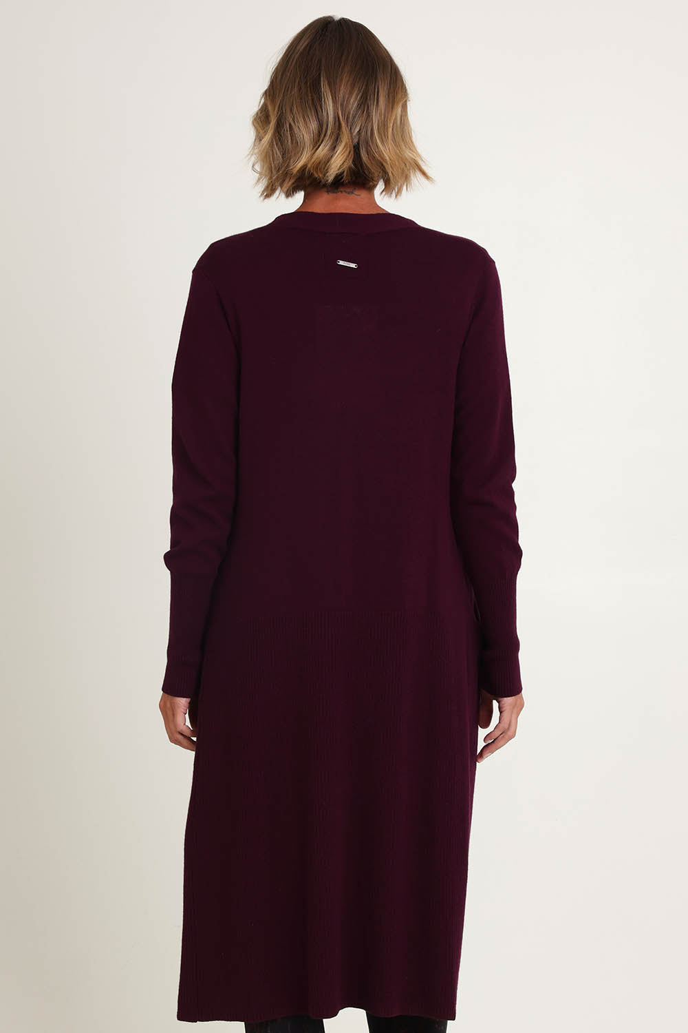 Model Riina wearing size S of the Luxe Line Cardi in colour Cherry (Purple), from the back