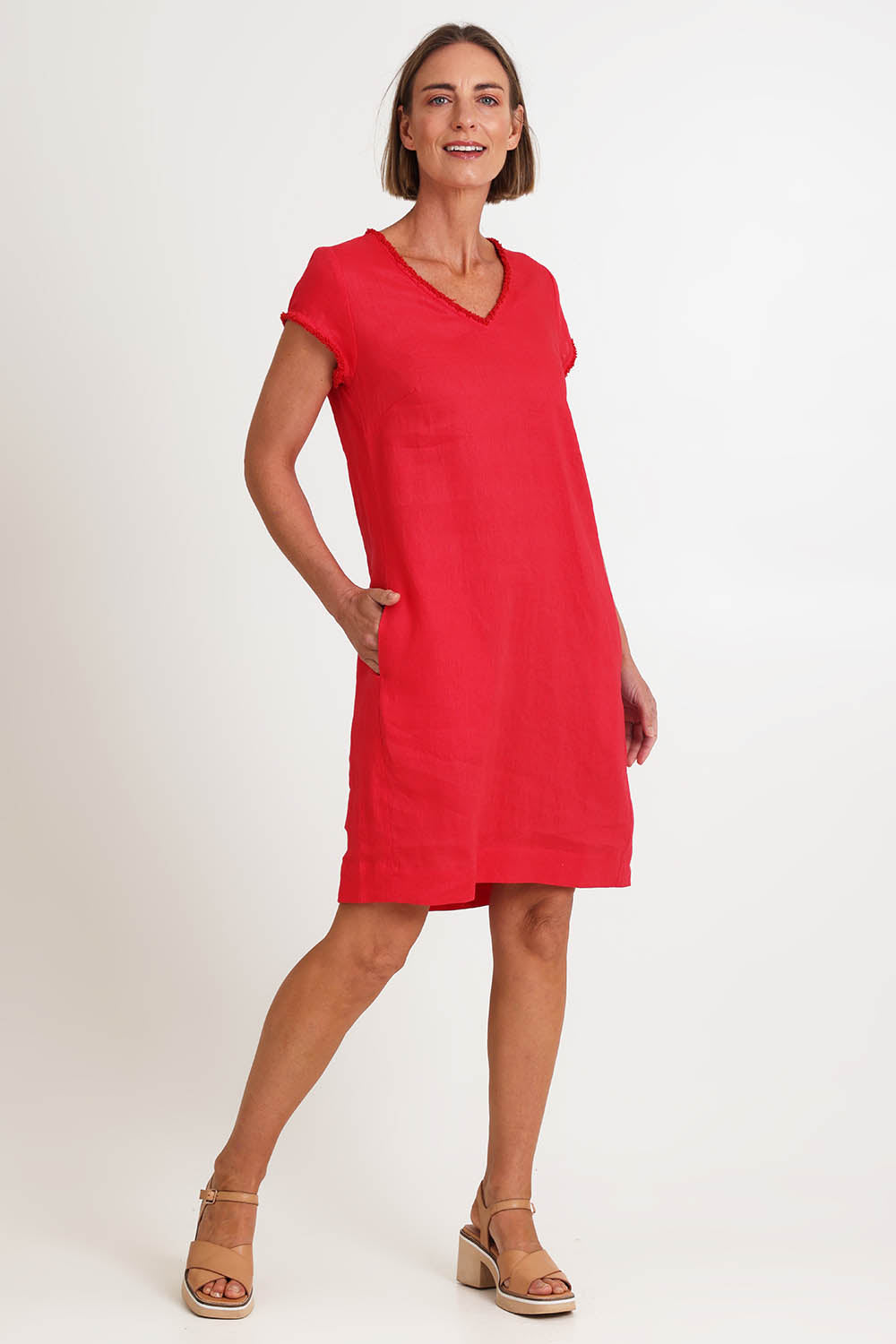 Model Riinar wearing size 10 of the V Festival Dress – Melon in colour Melon, from the front