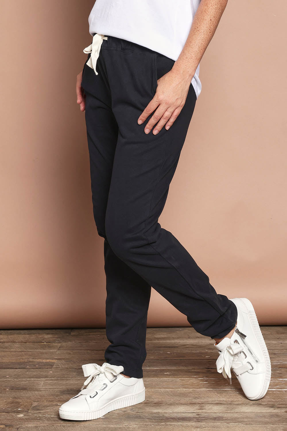 Model Katie wearing size 8 of the Elements Monday Cotton Pant in colour Black (Black), from the front, cropped image