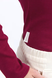 A model wearing the Elements Scoop Rib Cotton Blend  Long Sleeve in colour Beetroot (Red), from the front, cropped image
