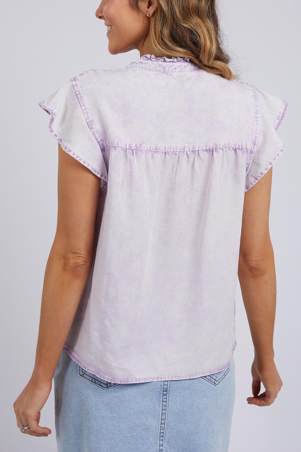 A model wearing the Reese Top in colour Lilac (Purple), from the back