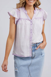 A model wearing the Reese Top in colour Lilac (Purple), from the front, cropped image