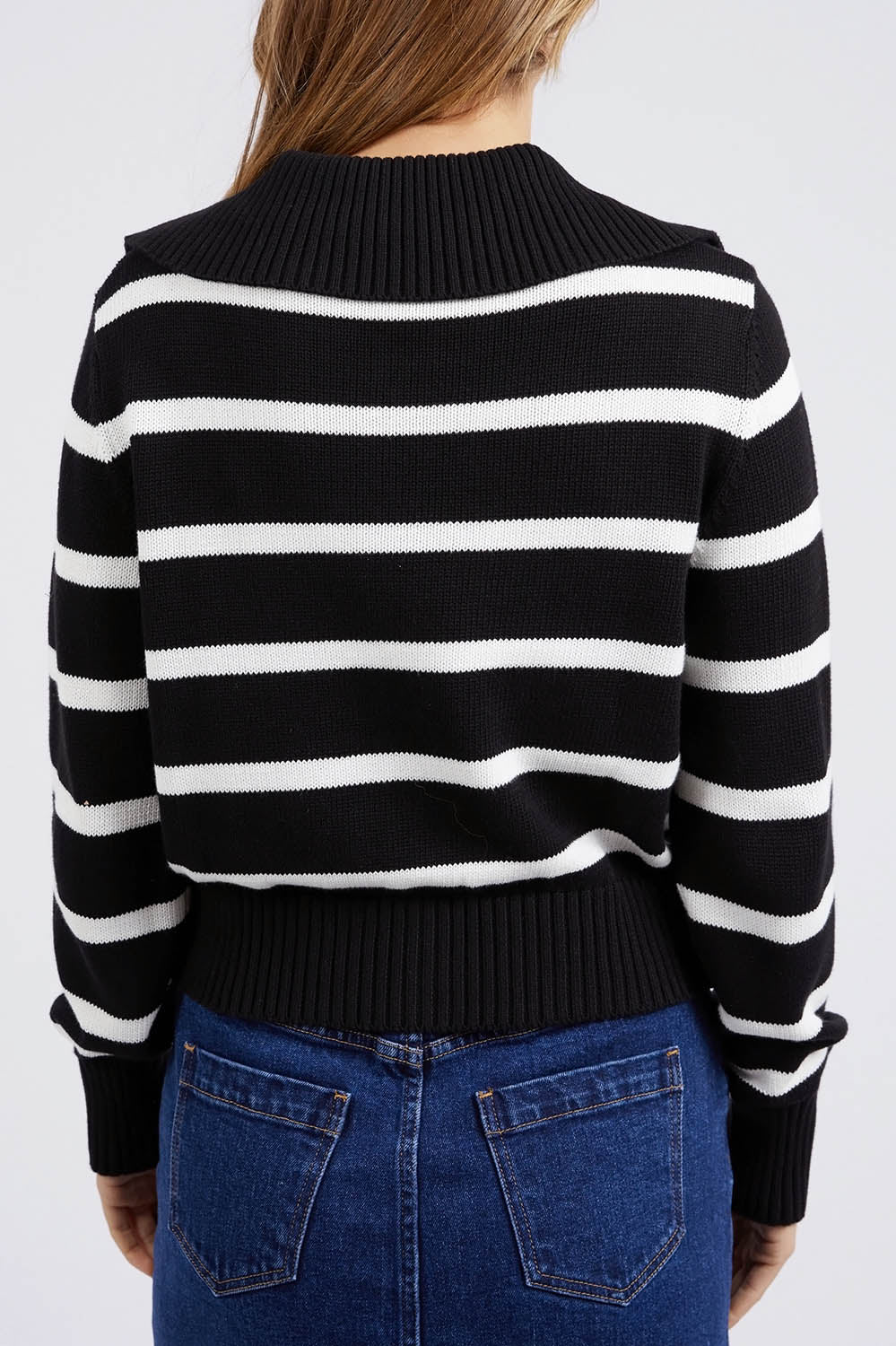 A model wearing the Effie Polo Knit in colour Blackwhite (Black), from the back