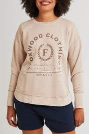 Model Grace wearing size 10 of the Leisure Medalion Crew in colour Oatmeal, from the front, cropped image