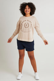 Model Grace wearing size 10 of the Leisure Medalion Crew in colour Oatmeal, from the front, showing the whole outfit