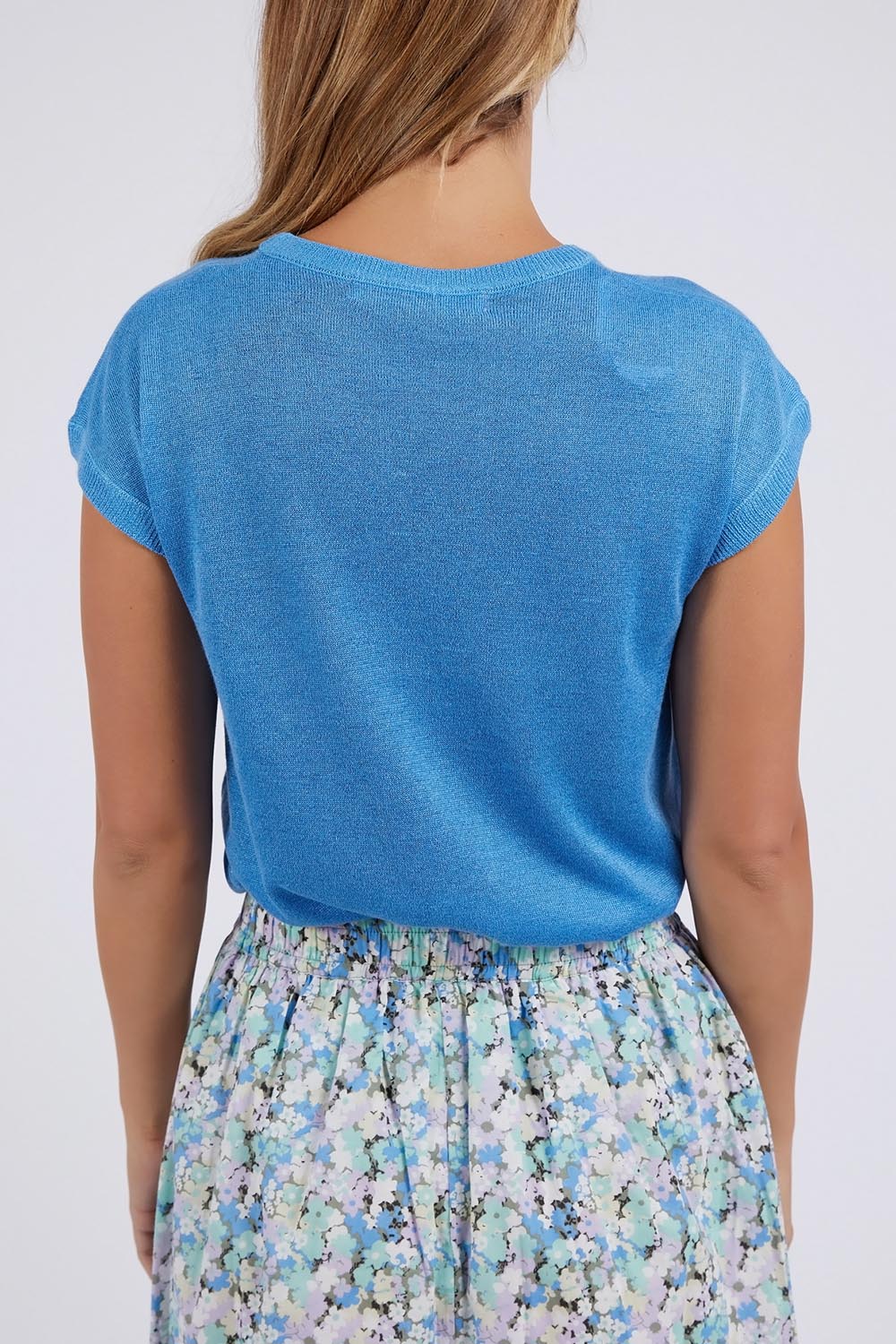 A model wearing the Alma Metallic Knit in colour Azureblue (Blue), from the back