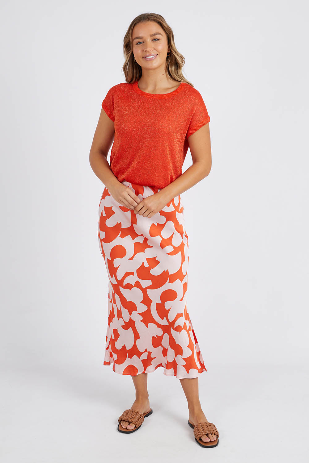 A model wearing the Alma Metallic Knit in colour Spcyorange, from the front, showing the whole outfit