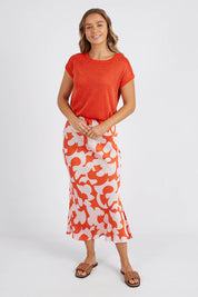 A model wearing the Alma Metallic Knit in colour Spcyorange, from the front, showing the whole outfit