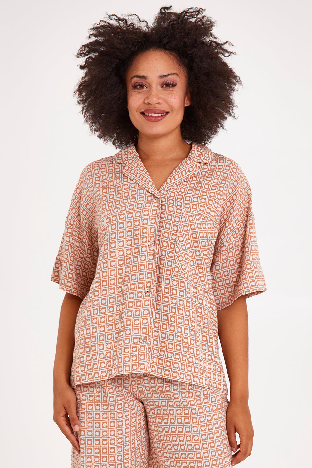 Model Olivia wearing size 10 of the Maya Geo Shirt in colour Mayageo, from the front, cropped image