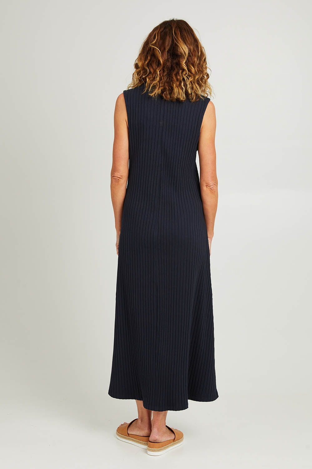 Model Emma wearing size 10 of the Pippa Rib Dress in colour Navy (Blue), from the back