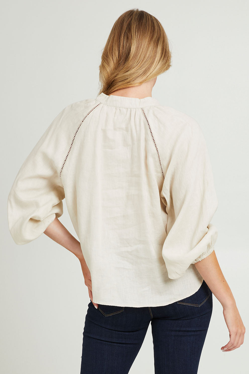 Model Grace wearing size 10 of the Sardina Blouse in colour Bone, from the back