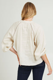 Model Grace wearing size 10 of the Sardina Blouse in colour Bone, from the back