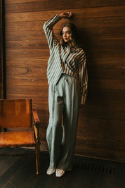 A model wearing the Naples Pant in colour Sage Green (Green), from the front, showing the whole outfit