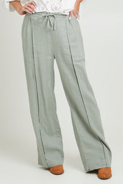 Model Grace wearing size 10 of the Naples Pant in colour Sage Green (Green), from the front, cropped image