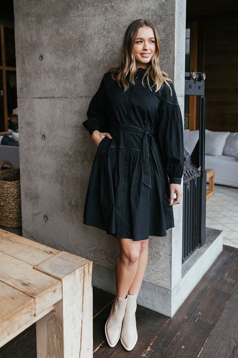 A model wearing the Goldie Dress in colour Black (Black), from the front, showing the whole outfit