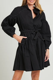 Model Grace wearing size 10 of the Goldie Dress in colour Black (Black), from the front, cropped image