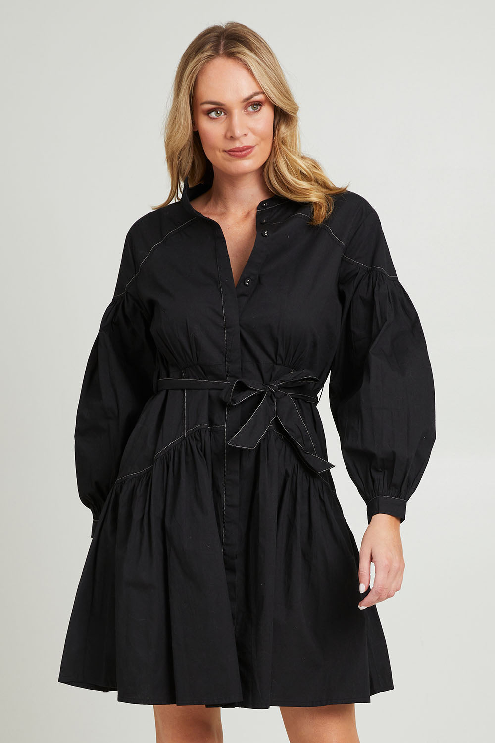 Model Grace wearing size 10 of the Goldie Dress in colour Black (Black), from the front, cropped image