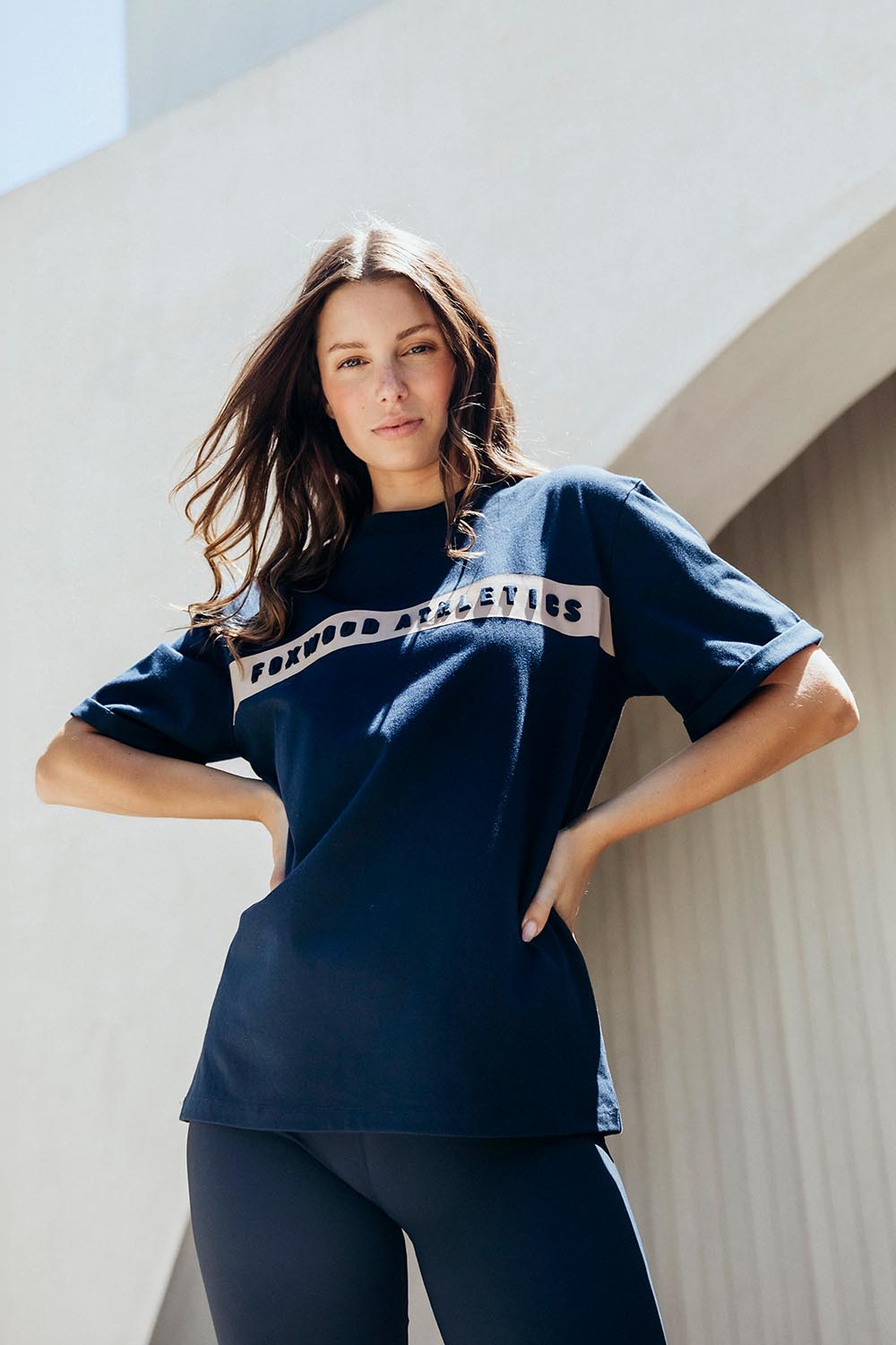 A model wearing the Leisure Foxwood Athletics Tee in colour Navy (Blue), from the front, showing the whole outfit