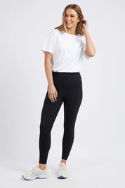 A model wearing the Leisure Luxe Rib Legging in colour Black (Black), from the front, showing the whole outfit