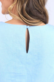 A model wearing the Bastia Linen Dress in colour Bluebelle (Blue), from the front, cropped image