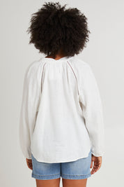 Model Olivia wearing size 10 of the Corsica Blouse in colour Vinwhite (White), from the back