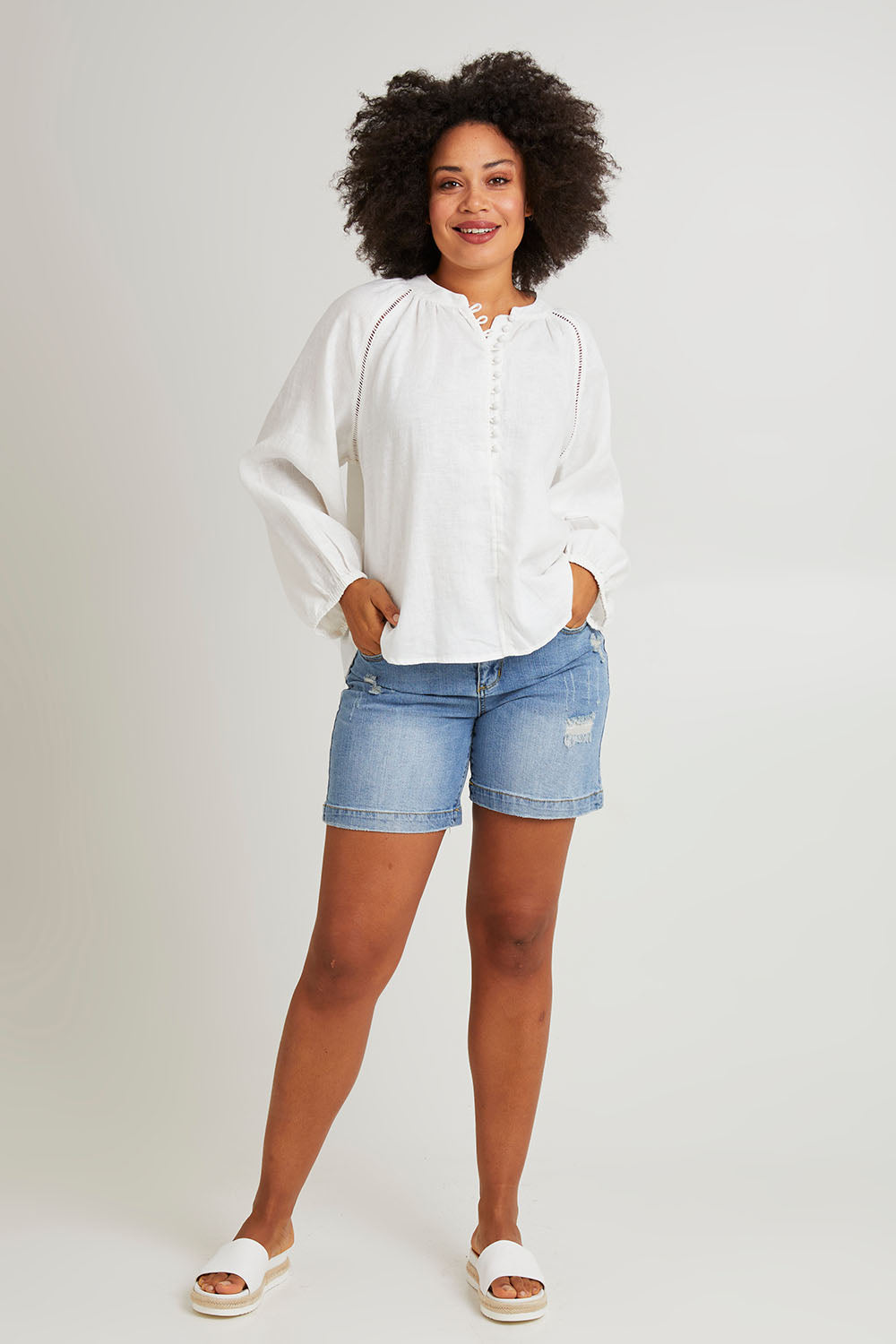 Model Olivia wearing size 10 of the Corsica Blouse in colour Vinwhite (White), from the front, showing the whole outfit
