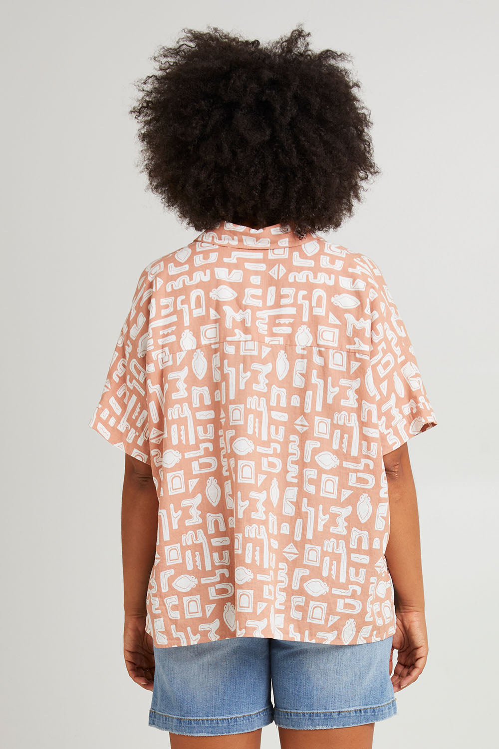 Model Olivia wearing size 10 of the Etched Geo Shirt in colour Clay, from the back